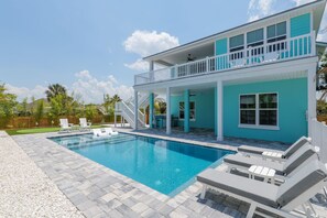 A two-story house with a swimming pool, outdoor seating, and a covered patio area. - Seashell Oasis - Heated Pool/Hot Tub/Putting Green/Walk to Beach (St. Augustine)