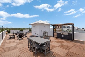A rooftop patio with a dining table, chairs, a barbecue grill, and a small white building. - 3 houses/3 pools/2 rooftops/panoramic ocean & downtown views (St. Augustine)