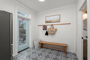 A hallway with a bench, a wall-mounted light fixture, and a framed picture. - Osprey Nest - Rooftop/Pool/Water Views (St. Augustine)