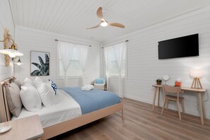 A bedroom with a bed, a desk, a chair, a TV, and a ceiling fan. - Osprey Nest - Rooftop/Pool/Water Views (St. Augustine)