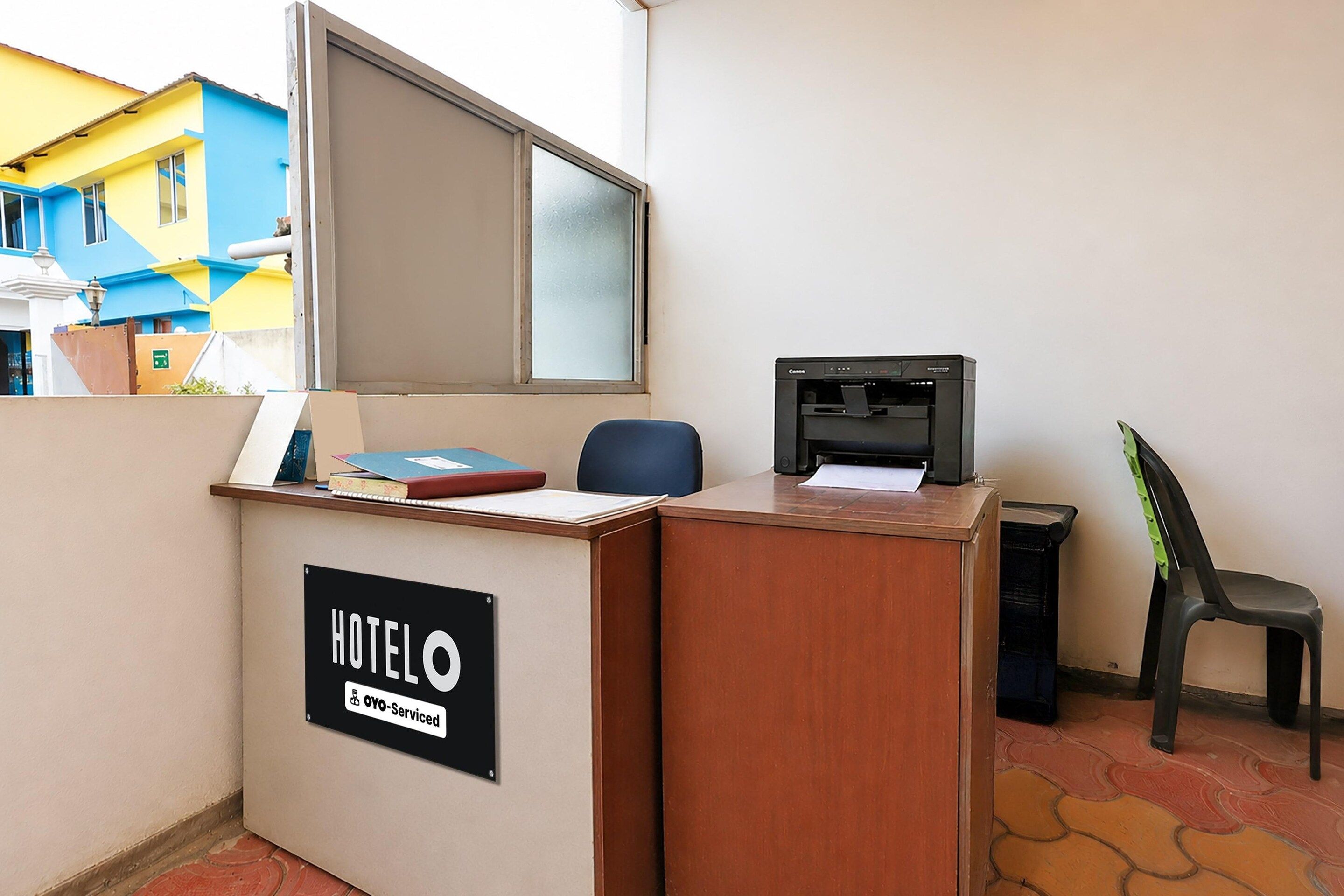 Ein Hotelrezeptionstresen mit einem Schild, das angibt, dass er von OYO bewirtschaftet wird.