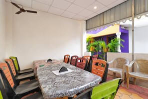 Zona de menjador amb taula, cadire i ventilador de sostre.