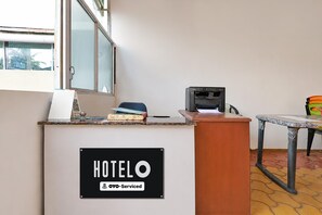 A hotel reception desk with a sign indicating it is serviced by OYO.