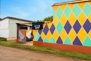 A building with a colorful diamond-patterned exterior wall and a sign that reads 'HOTEL OYO-Serviced.'
