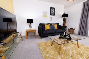 A modern living room with a sofa, coffee table, and a television. - Central Lerwick House, Modern, 2 Bathrooms, Garden (Lerwick)