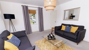 Un salon moderne avec un canapé, une table basse, un lampadaire et un miroir au mur.