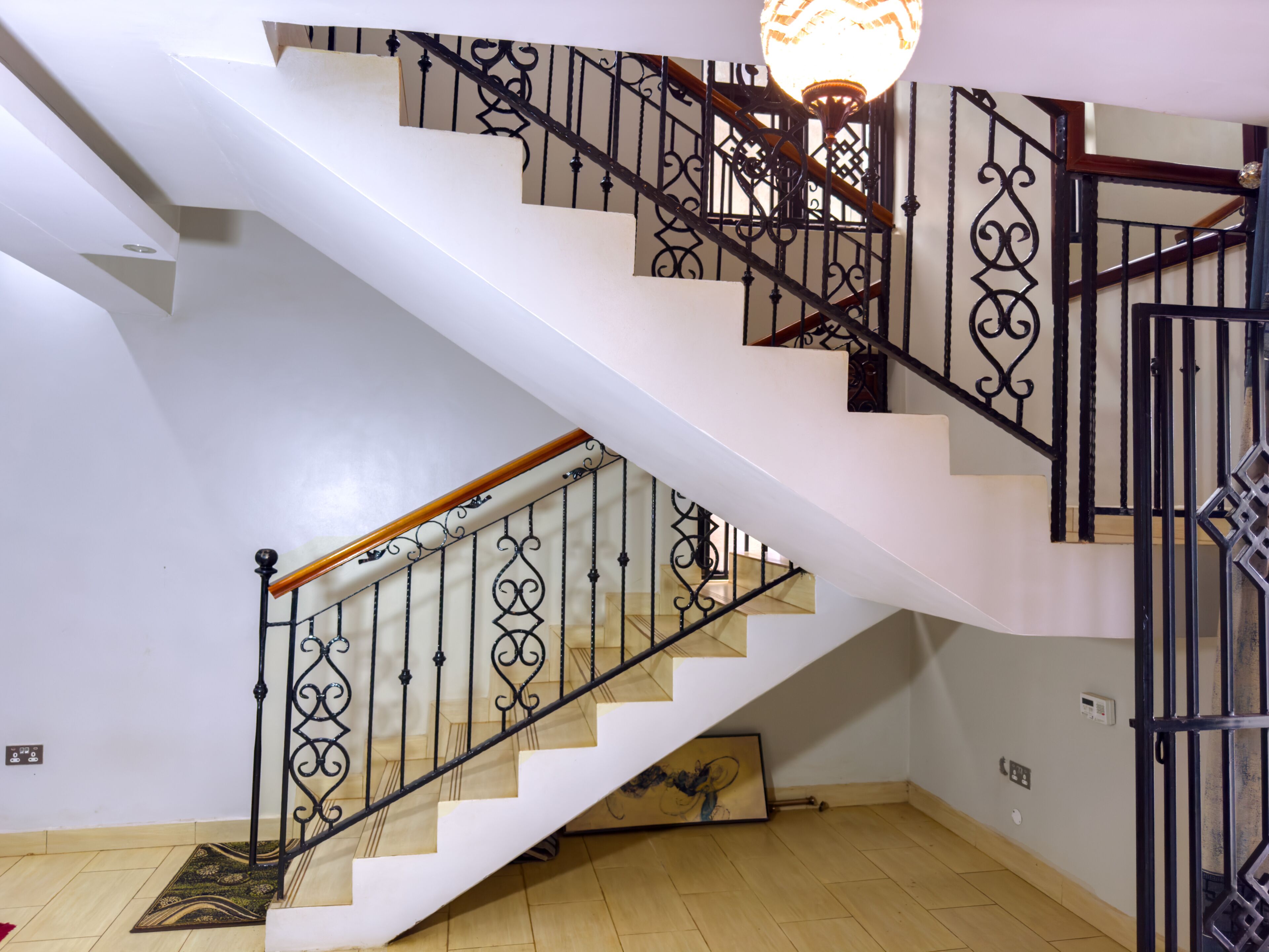 A multi-level staircase with ornate metal railings and wooden handrails.