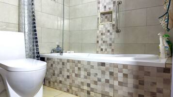 Ein Badezimmer mit Toilette, Dusche und Badewanne.