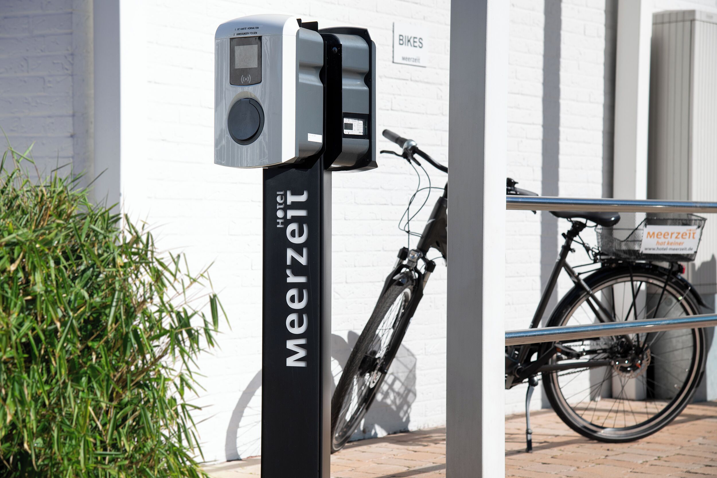 Ein Fahrradstellplatz mit einem Schild, auf dem 'Meerzeit Hotel' steht.