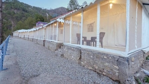 Filas de habitaciones con ventanas individuales y un muro de piedra como base.