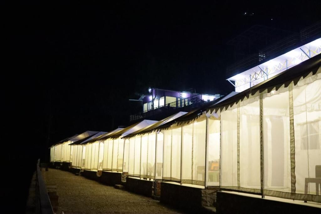 A row of tents with a balcony and a staircase leading to a higher level.