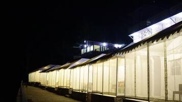 A row of tents with a balcony and a staircase leading to a higher level.