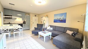 A compact living space with a kitchenette, a dining area, a sofa, and a painting on the wall. - Fantastic vacation rental "FeWo Lieblingsplatz" right on the beach in California O (Schönberg (Holstein))