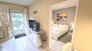 A room with a bed, a desk, a chair, and a view of the outdoors. - Fantastic vacation rental "FeWo Lieblingsplatz" right on the beach in California O (Schönberg (Holstein))