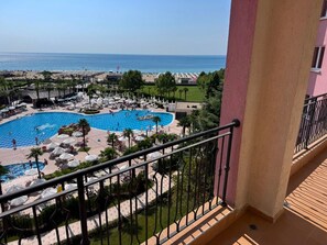 A resort with a large pool, sun loungers, and a view of the sea. - Modern Seaview Apartment  50m to Beach  AC & Gym. (Sunny Beach)