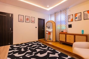 Un dormitorio con cama, espejo, armario, sofá y aparador.