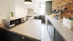 Eine Küche mit Granitabdeckung, integriertem Backofen, Spüle und einer hängenden Pfannenstange.