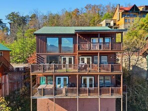 A multi-story log cabin with balconies, large windows, and a green roof. - Robin's View | Hot Tub, Indoor Pool, Unbeatable Mountain Views! (Pigeon Forge)