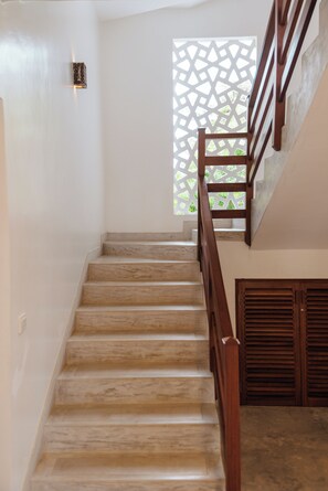 Una escalera con barandillas de madera que lleva a un rellano.