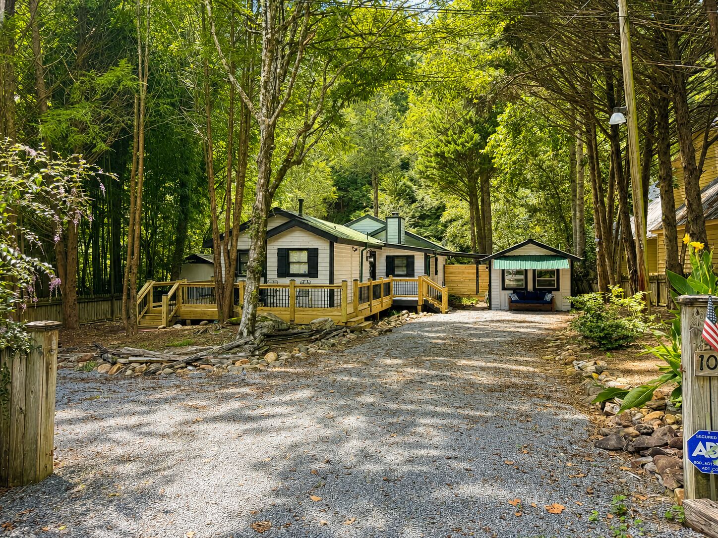 Un camping con dos cabañas, un camino de grava y una valla de madera.