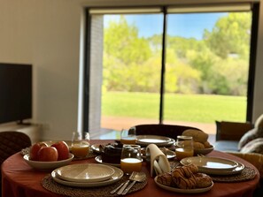 A breakfast table set with plates, cutlery, and a bowl of apples. - Vilamoura Prestige 3 With Pool by Homing (Loulé)