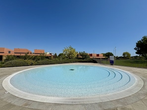 A circular pool with a textured edge, surrounded by a paved walkway. - Vilamoura Prestige 3 With Pool by Homing (Loulé)