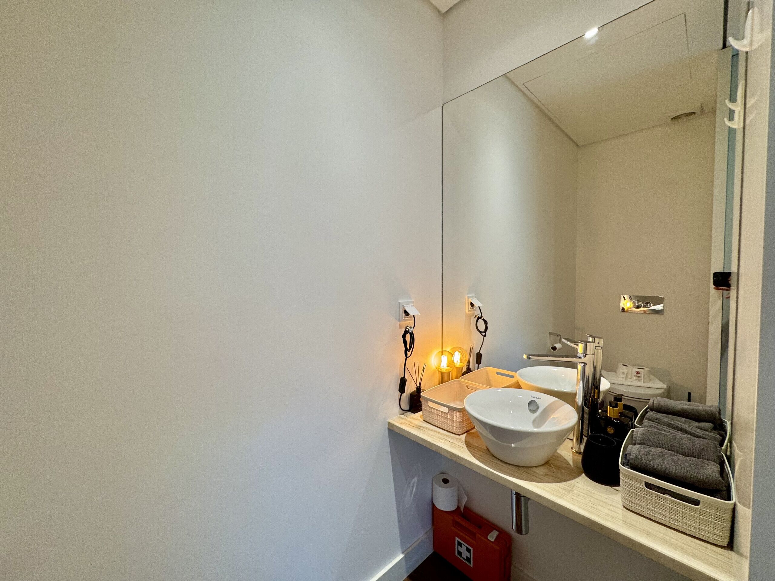 Uma casa de banho moderna com duas pias, um espelho grande e um porta-toalhas.