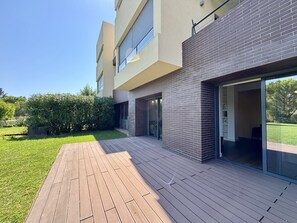 Un bâtiment moderne doté d’un toit plat, d’une façade en briques et d’une terrasse en bois.