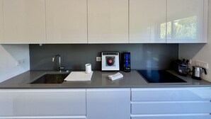 A modern kitchen with two sinks, a built-in oven, and a coffee maker. - Vilamoura Prestige 3 With Pool by Homing (Loulé)