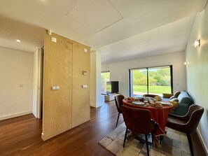 A modern dining area with a wooden cabinet, a television, and a view of the outdoors. - VILAMOURA PRESTIGE 3 WITH POOL by HOMING (Vilamoura)