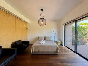 A modern bedroom with a large bed, a hanging light fixture, and a view through a large window. - VILAMOURA PRESTIGE 3 WITH POOL by HOMING (Vilamoura)