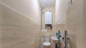 Casa de banho pequena com sanita, bidé e secador de mãos.