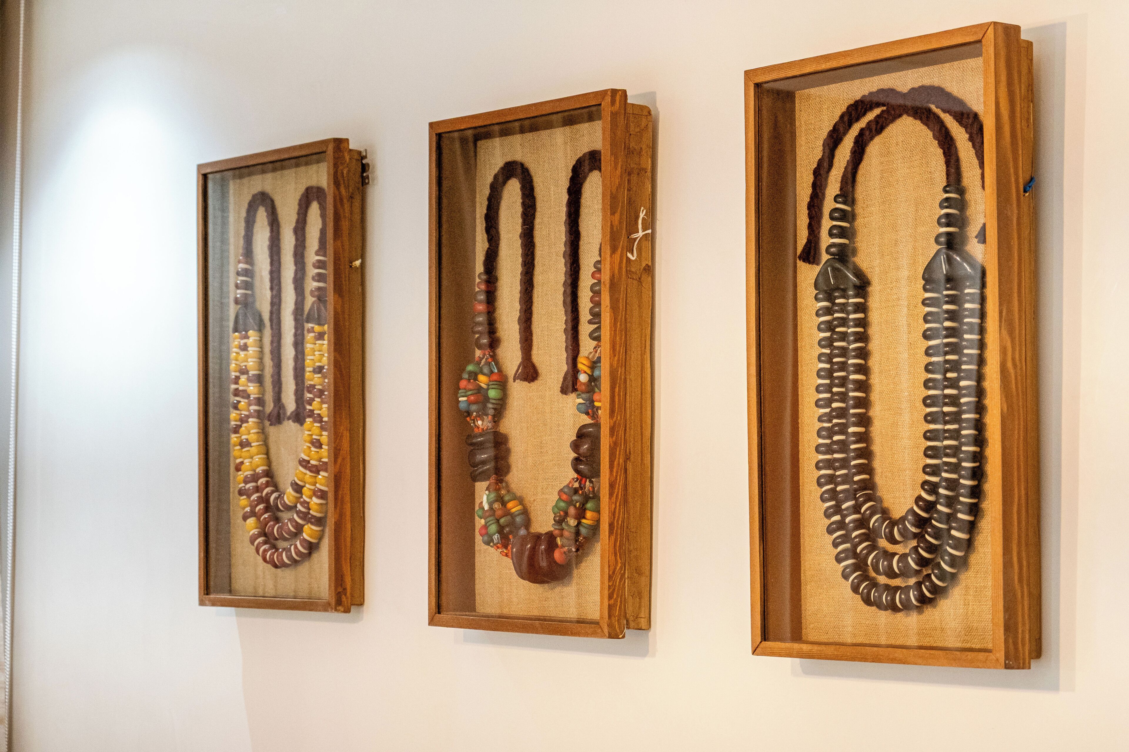 Tres collares expuestos en vitrinas.