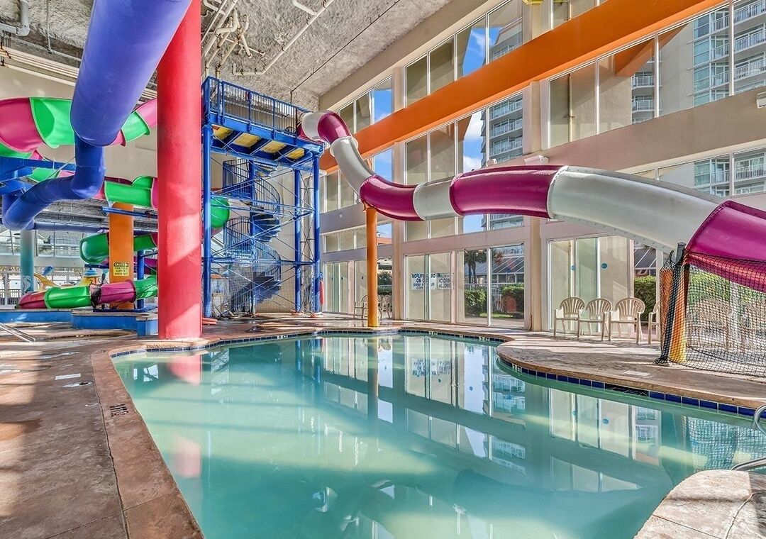 An indoor pool area with a water slide and a pool.