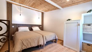 A room with two beds, wooden ceiling, white walls, and a white wardrobe with baskets. - Cottage with countryside view - 2 guests (Saint-Just-Saint-Rambert)