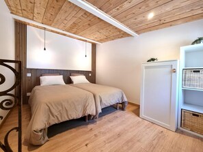 A room with two beds, wooden ceiling, white walls, and a white wardrobe with baskets. - Cottage with countryside view - 2 guests (Saint-Just-Saint-Rambert)