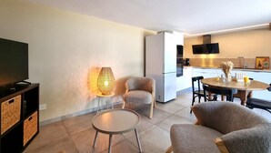 A modern living room with a flat-screen TV, a round coffee table, and two armchairs. - Cottage with countryside view - 2 guests (Saint-Just-Saint-Rambert)