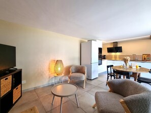 A modern living room with a flat-screen TV, a round coffee table, and two armchairs. - Cottage with countryside view - 2 guests (Saint-Just-Saint-Rambert)
