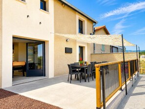 Una casa moderna con patio, mobiliario exterior y vista al mar.