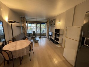 A compact kitchen with a dining area, a refrigerator, and a television. - Apartment, pets welcome, sea view - 4 guests (Saint-Cyprien)