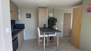 A compact kitchen with a dining area, a sink, and a potted plant. - Romantic apartment sea view, 2 guests (Le Lavandou)