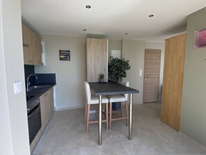 A compact kitchen with a dining area, a sink, and a potted plant. - Romantic apartment sea view, 2 guests (Le Lavandou)