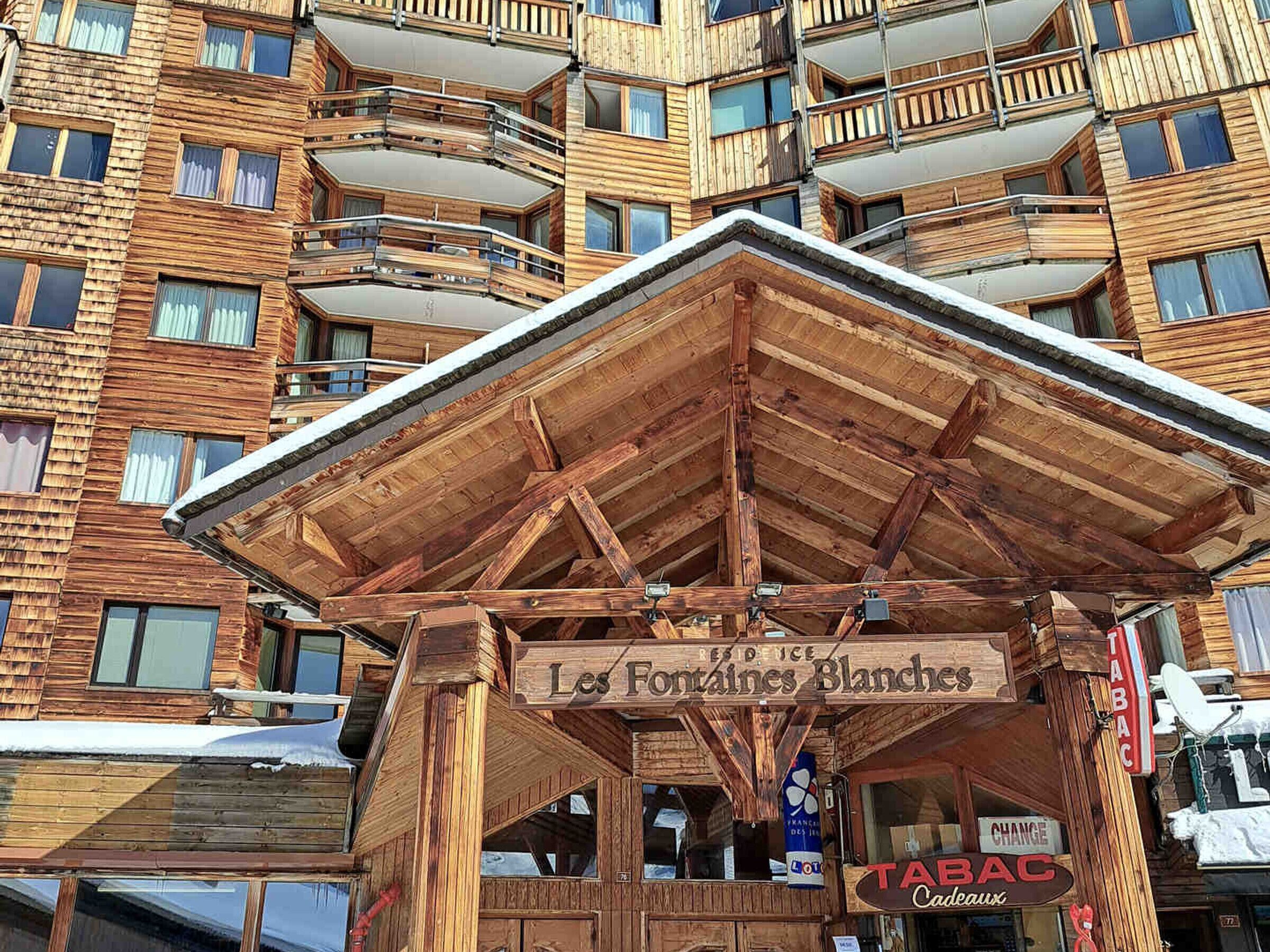 A wooden chalet with a sign reading "Les Fontaines Blanches".