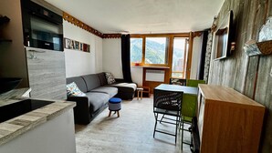 A compact living space with a kitchenette, a sofa, a dining table, and a view of the outdoors. - Apartment in the heart of Avoriaz - 4 guests (Avoriaz)