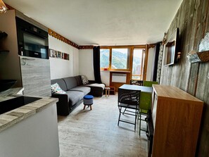 A compact living space with a kitchenette, a sofa, a dining table, and a view of the outdoors. - Apartment in the heart of Avoriaz - 4 guests (Avoriaz)