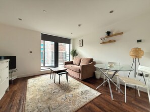 Ein modernes Wohnzimmer mit einer Couch, einem Glastisch und einem Couchtisch.