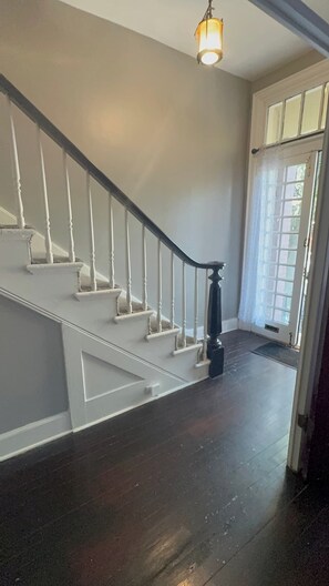 A staircase with white railings and dark wooden steps leading to a landing.