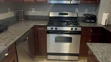 A kitchen with wooden cabinets, a stainless steel stove, and a microwave.