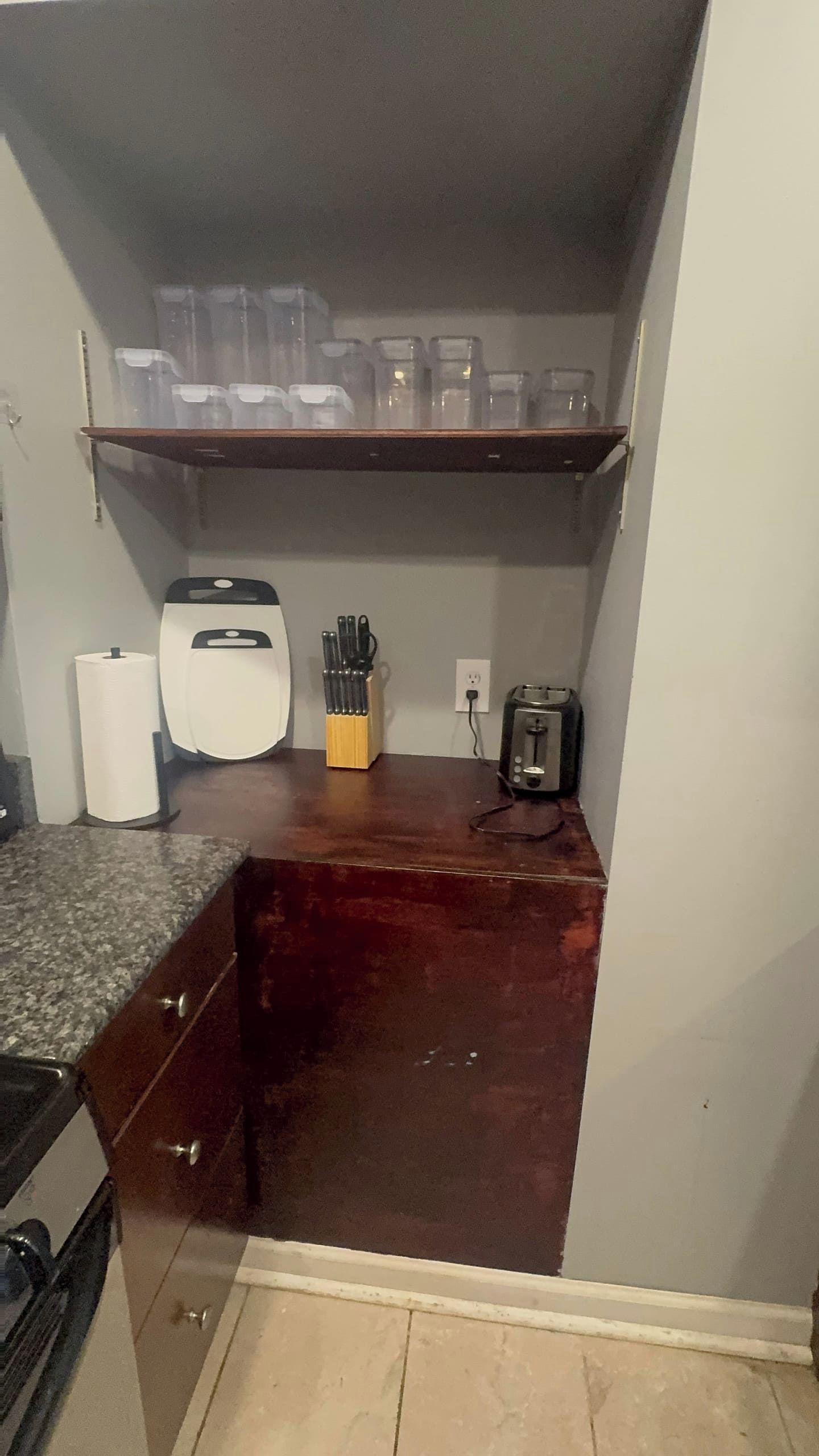 Et kompakt køkken med bordplade, kaffemaskine, brødrister og knivblok.