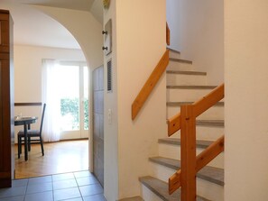 Eine Treppe mit Holzhandläufen und eine Essecke mit Tisch und Stühlen.
